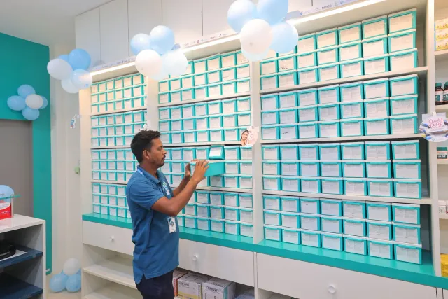 A team member checks the aqua storage drawers between opening moments. — Bikram