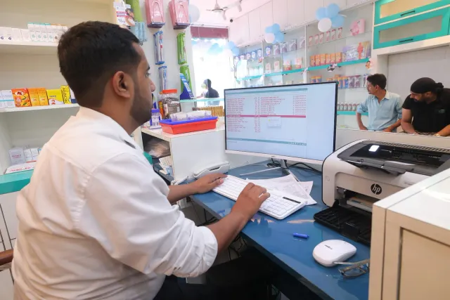Paperwork and computer work come together at the pharmacy desk. — Bikram