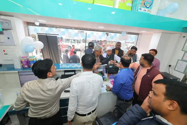 A candid conversation across the counter during the celebrations. — Muharram Chowk