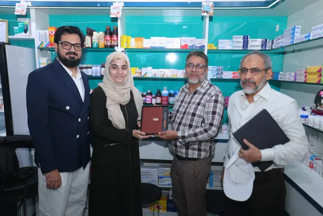 A commemorative presentation brings guests together at the pharmacy. — Sherghati