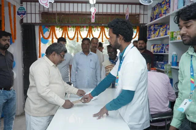 A handshake across the counter welcomes guests to the store. — Parsagarh Bazar