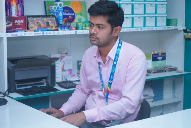 A quiet moment of computer work at the pharmacy desk. — Parsagarh Bazar