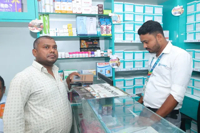 A friendly exchange across the counter during the gathering. — Bartand, Dhanbad