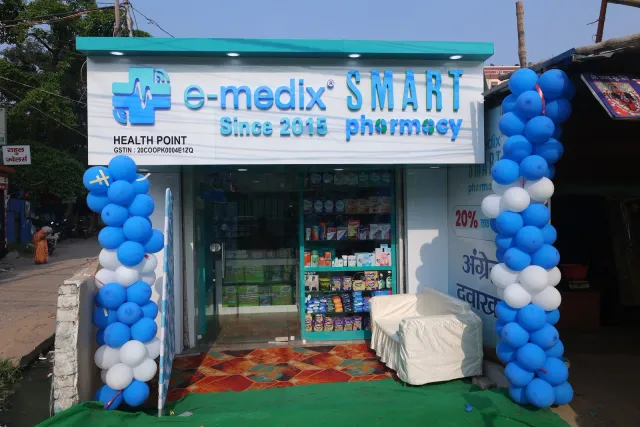 Blue-and-white balloons frame the pharmacy's daytime entrance. — Bartand, Dhanbad