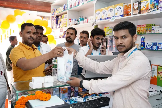 A pharmacy bag is presented across the counter during the celebrations. — Godhna Road