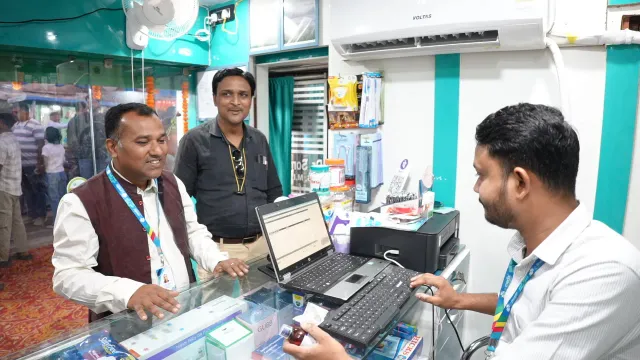 A candid view of computer work across the pharmacy counter. — Jamalpur, Munger