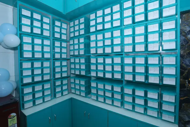 Rows of aqua drawers reveal the pharmacy's storage layout. — Mubarakpur, Danapur