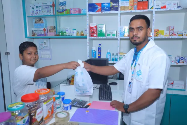 A pharmacy bag is passed across the counter during the gathering. — Mubarakpur, Danapur