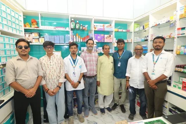 Guests come together for a group photograph inside the pharmacy. — Tribhuvan More