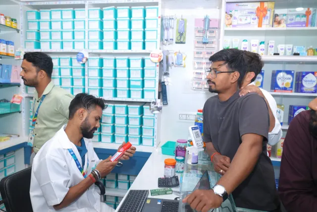 A quieter conversation takes place over an item at the counter. — Housing Colony Kankarbagh