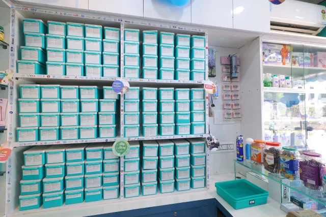 Aqua drawers and glass shelving show the store's organised interior. — Housing Colony Kankarbagh