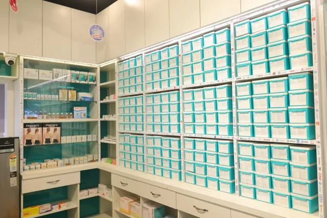 Rows of aqua drawers reveal the pharmacy's organised storage layout. — Patepur road, Mahua