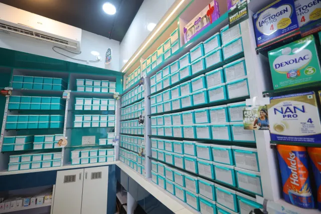 A close-up of the aqua storage drawers inside the pharmacy. — Usri Bazar